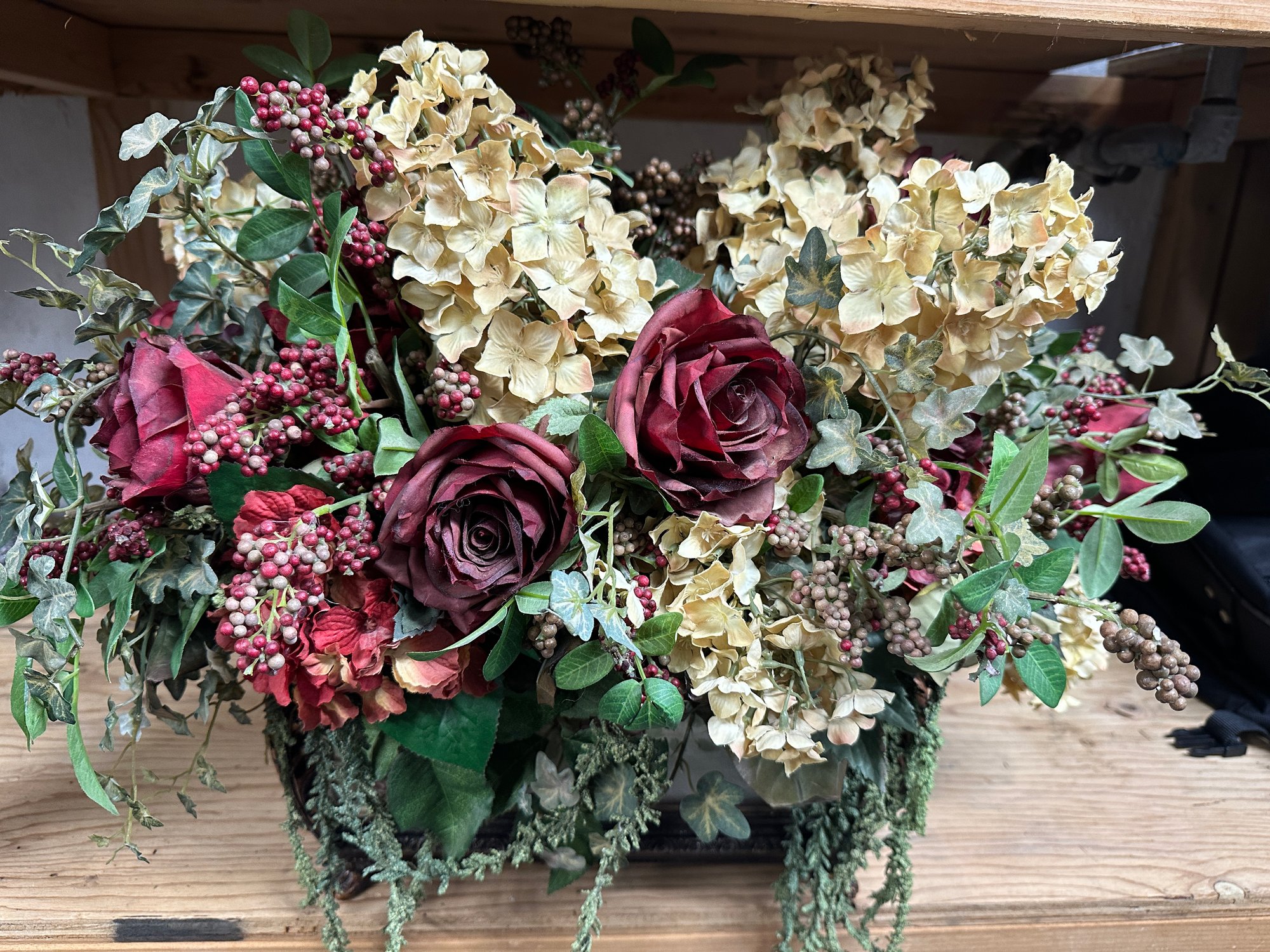 A Vintage Trunk With An Abundant Silk Floral Arrangement With Roses And ...