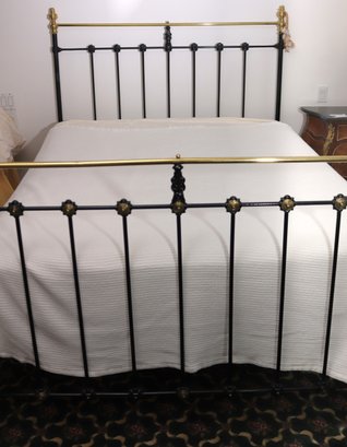 An Antique Black Painted Metal Queen Size Bed With Brass Finials.