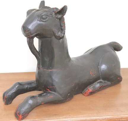 A Carved And Black Painted Seated Goat Statue, With Several Age Cracks