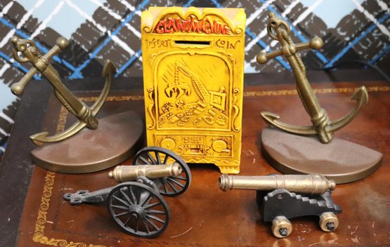 Vintage Decorative Metal Items With Brass Anchor Bookends, Mini Cannons, And Clay Bank.