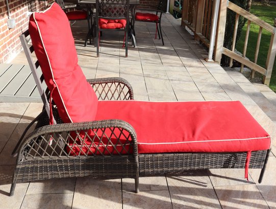 An Adjustable Weather Wicker Lounge Chair With Red Cushions.