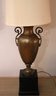 Tall Brass Urn Shaped Lamp With Handles On A Wood Base