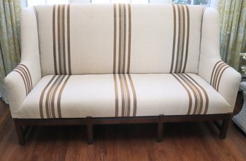 Tall Wing Back Settee Sofa With Wooden Legs & Nubby Linen Fabric Highlighted By Nail Heads.
