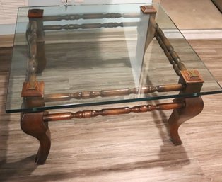 Transitional Style Glass Top Coffee Table With Wooden Base And Curved Legs.