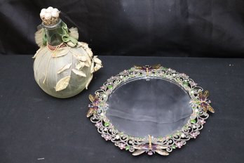 Round Vanity Mirror With Enamel Butterfly Frame Style Of Jay Strongwater And Decorative Bottle.