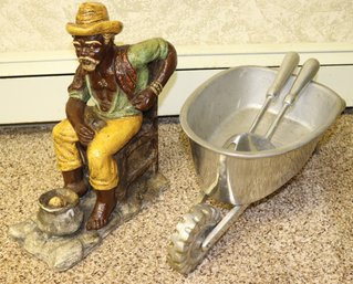 Signed Ceramic Figure Of Seated Black Man And  Aluminum Wheelbarrow With Serving Pieces