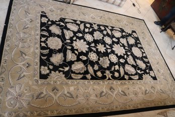 Machine Made Area Rug With Floral Design On Black Background And Tan Border.