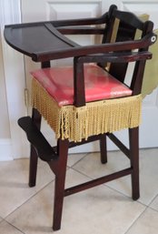 A Vintage Wooden Highchair Decorated With Gold Wings.