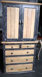 A Rustic Style Cabinet With Wood Panel Doors And Distressed Blue Painted Trim.