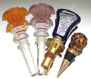 Two Versace Rosenthal Crystal Medusa Bottle Stoppers, And 2 Others.