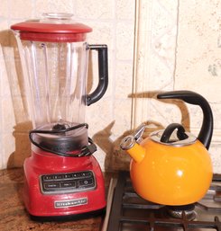 Red Kitchen Aid Blender With Plastic Container, And An Orange Teakettle.