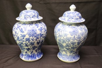 Two Porcelain Lidded Urns With Blue And White Floral Designs.