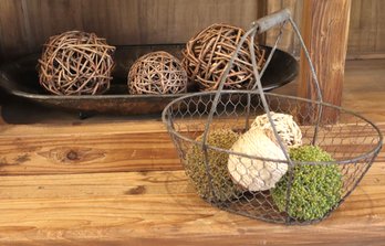 A Hand Hammered Oval Bowl In Bronze Finish And Basket With Decorative Twig Balls.