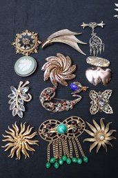 An Assortment Of Vintage Mid-century, Pins, Featuring Starburst Designs, And Some With Rhinestones.