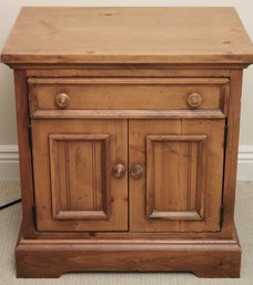 Pine Nightstand In A Honey Color Finish With Drawer And Doors.