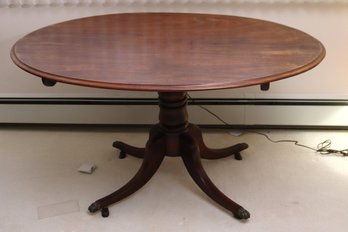 Oval Walnut Dining Table With Center Pedestal And Ball And Claw Feet With Casters.