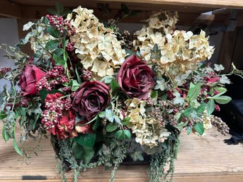 A Vintage Trunk With An Abundant Silk Floral Arrangement With Roses And Hydrange