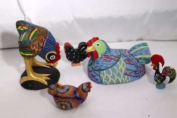 Five Roosters Inspired Decorative Items With Candle, Carved Signed Roosters And Two Smaller Pieces.