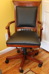 Vintage Swivel Office Chair With Wooden Frame And Black Faux Leather Upholstery.