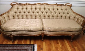 1940s Era Hollywood Regency Style Tufted Back Sofa With Wooden Frame And Gold Tone On Tone Fabric.