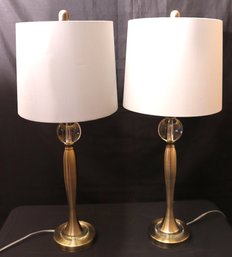 Pair Of Stylish Table Lamps In A Brass Finish With A Glass Orb Center