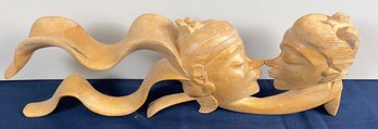 Flowing Wood Carving Of A Couple Kissing.