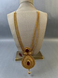 Gold Tone Red Glass Necklace With Medallion.