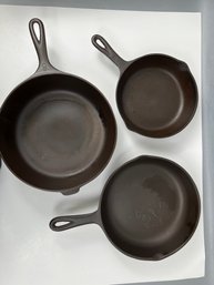 3 Cast Iron Pans, Wagner Dutch Oven, Unmarked #7 And A Unmarked #5.