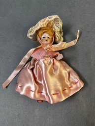 Small Porcelain Doll In A Pink Dress.
