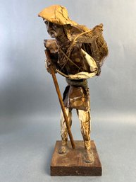 Paper Mache Figure Of A Man Carrying Cooking Stones On His Back.