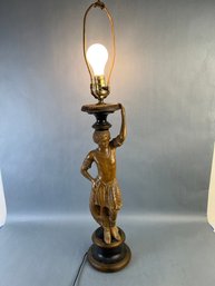 Carved Wood Statue Of A Native Man Holding A Lamp On His Head.