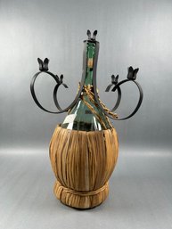 2 Black Metal Candleholders Sits Op Top Of Wine Bottle.