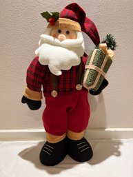 Tall Santa Wearing Sweater And Carrying Package