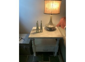 White Side Table With A Lamp And Decor Bottles