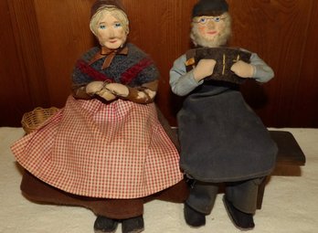 PAIR OF EARLY DOLLS SITTING ON A WOODEN BENCH