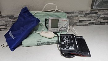 Two Blood Pressure Monitors And A Heating Pad