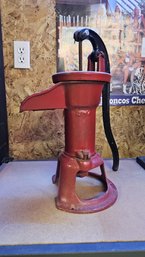 Vintage Water Pump In Red And Cast Iron Antique Machinery Wheel With Festive Paint Details