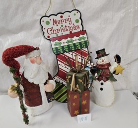 Collection Of Christmas Decor: Santa Statue, Snowman, Gift Boxes, And A Hanging Merry Christmas Stocking