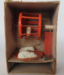A Mechanical Mice Toy Housed Within A Cardboard Box - Cranking The Handle On The Side Causes Three Different M