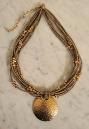 'JOAN RIVERS' GOLDTONE MULTISTRAND(10) NECKLACE WITH LARGE GOLDTONE PENDANT