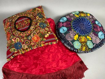 Two Decorative Pillows In Vibrant Colors And Round Red Fringed Tablecloth