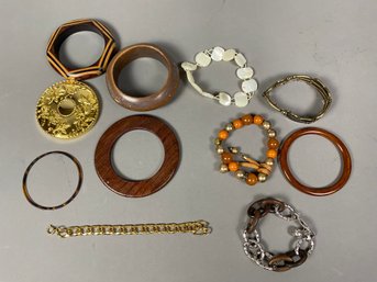 Variety Of Costume Jewelry Including Wood, Metal, Plastic, And Beaded Bracelets And A Mirror