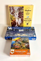 Assortment Of 1000 Piece Puzzles W/ Positano Italy, Rupp Arena, & Shadow By Jonathon Bowser - Lot Of 3