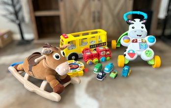 Assortment Of Toddler Friendly Toys Featuring A Walker, Shape Train , Rocking Horse, Easy Grip Cars And More