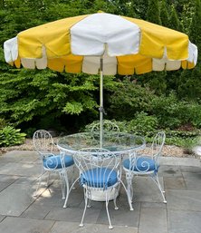 Glass Top Patio Table With Four Chairs And Yellow Striped Umbrella