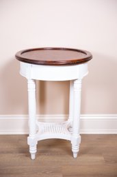 A Circular Wooden Table With White Painted Wooden Legs