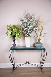 A Set Of Three Floral Arrangements In Antiqued Vessels