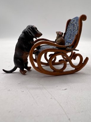 An Austrian Bronze Dachshund With Mouse Sitting On A Rocking Chair