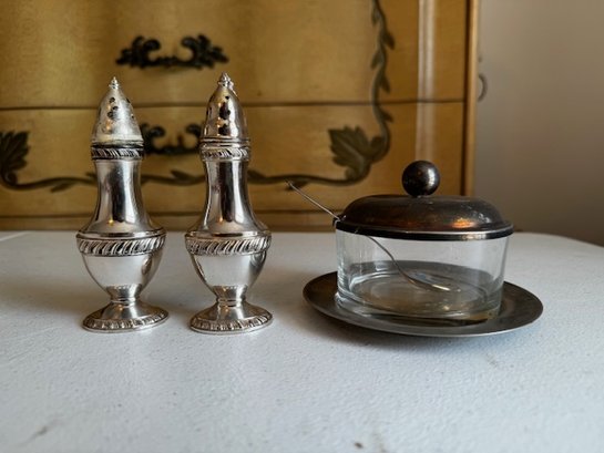 A Group Of Silver Plate Salt And Pepper Shakers And Sugar Bowl With Spoon
