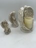 A Group Of Three Angels Figurines One Candle